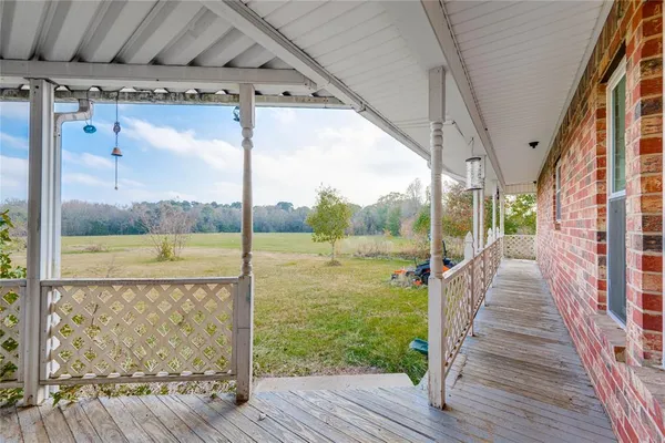 a view of a porch with wooden floor and fence