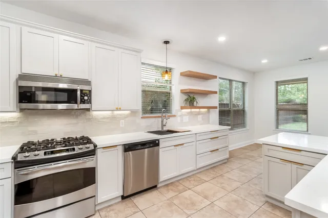 a kitchen with a sink stove top oven and cabinets