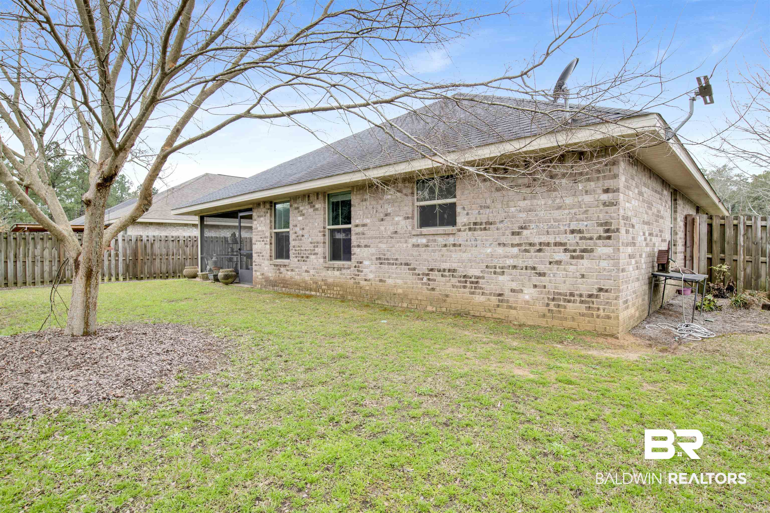 22056 Garland Loop Silverhill, AL 36576 - Photo 27 of 28 Back of house with a fenced backyard, brick siding, and a yard