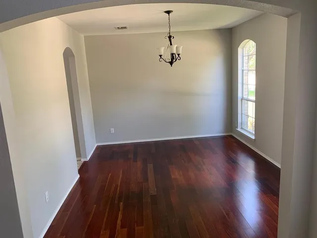 a view of a room with wooden floor and windows