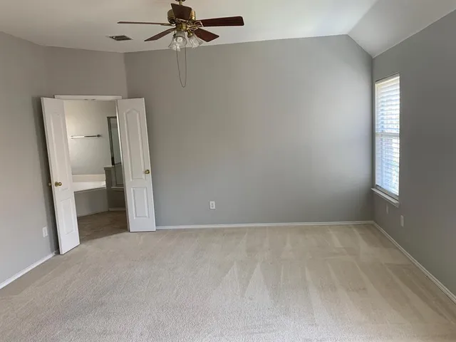 a view of a room with an empty space and a window