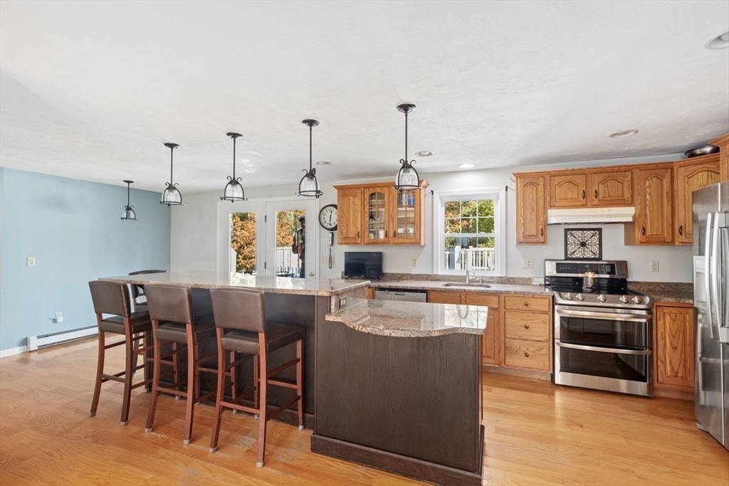102 Haskell Ridge Road Rochester, MA 02770 - Photo 5 of 36 a kitchen with stainless steel appliances kitchen island granite countertop a table chairs sink and cabinets