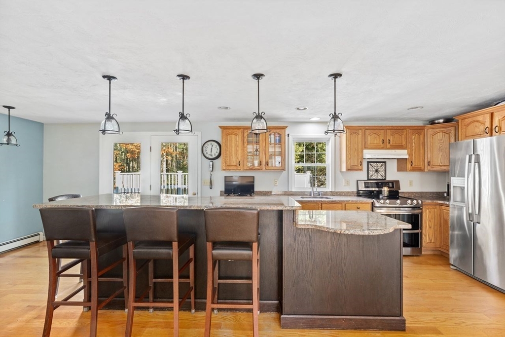 102 Haskell Ridge Road Rochester, MA 02770 - Photo 6 of 36 a kitchen with stainless steel appliances granite countertop a stove top oven a refrigerator a sink with island chairs and cabinets
