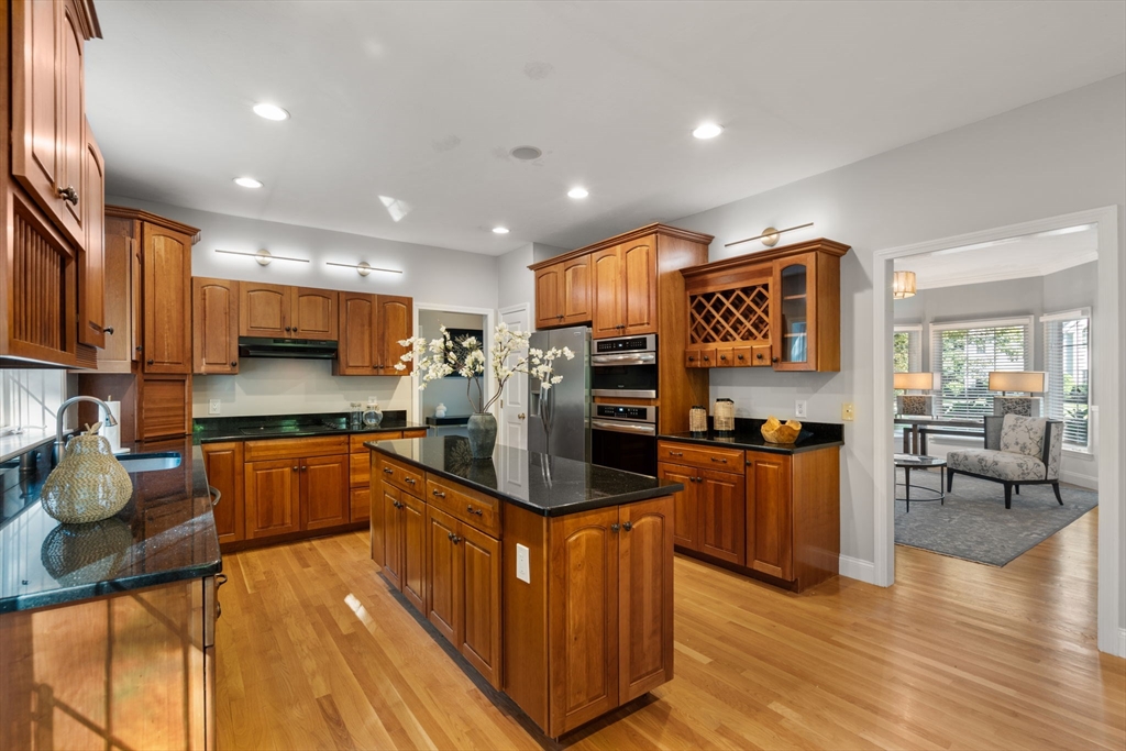 15 Broad Acres Farm Road Medway, MA 02053 - Photo 11 of 42 a kitchen with stainless steel appliances granite countertop wooden cabinets a refrigerator a stove a sink and a dining table with wooden floor