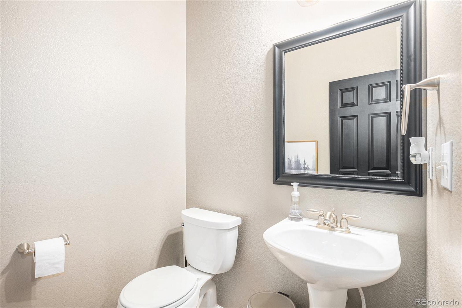 2470 Robindale Way Castle Rock, CO 80109 - Photo 14 of 42 a bathroom with a toilet sink and mirror