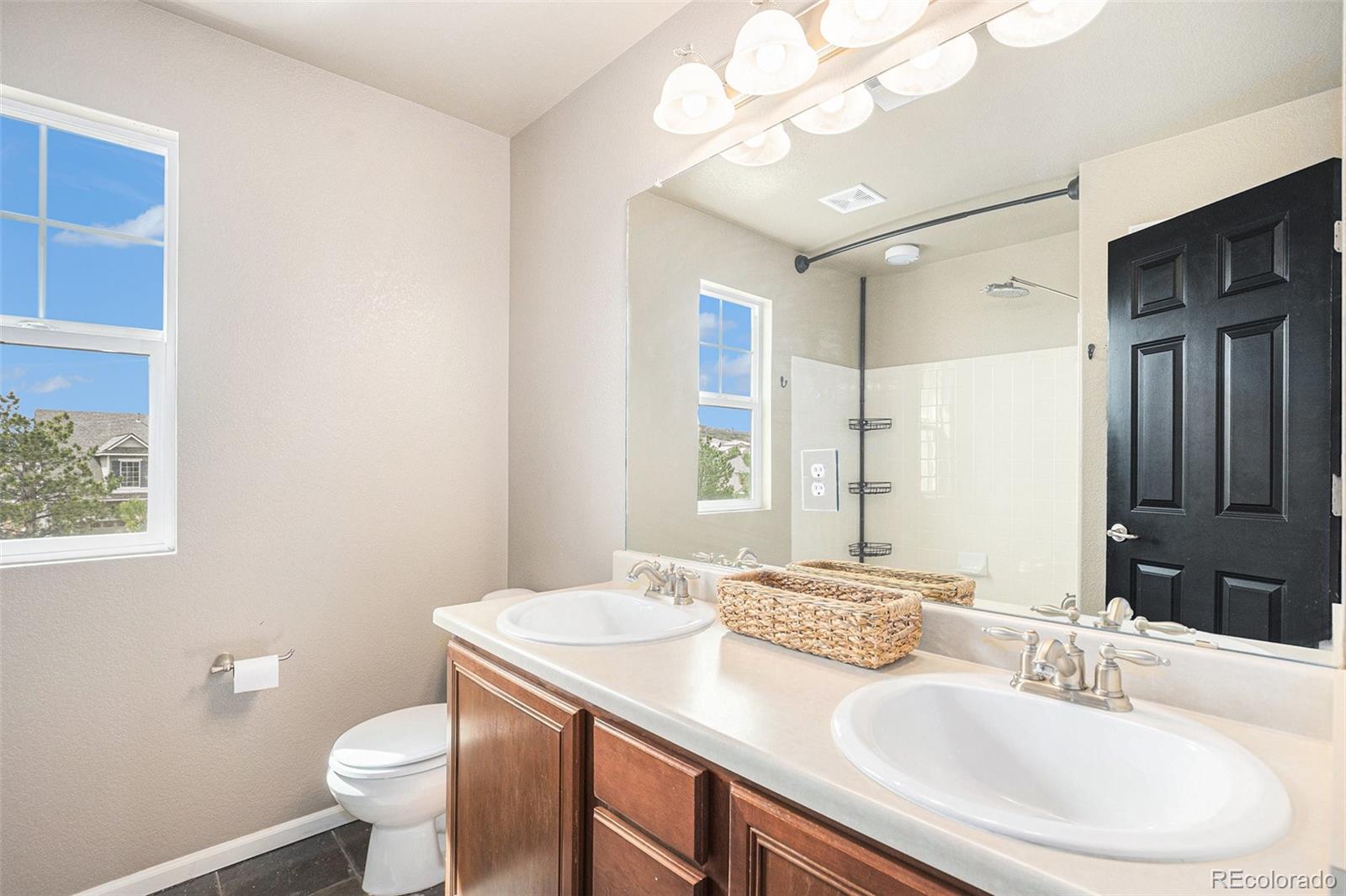 2470 Robindale Way Castle Rock, CO 80109 - Photo 27 of 42 a bathroom with a granite countertop sink a toilet and a mirror