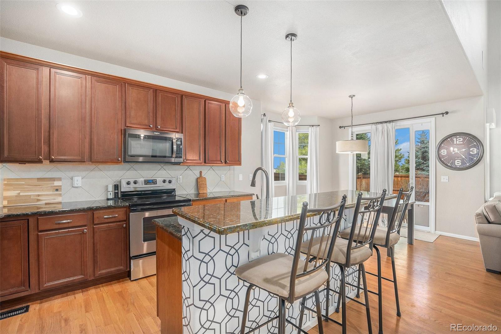 2470 Robindale Way Castle Rock, CO 80109 - Photo 7 of 42 a kitchen with stainless steel appliances granite countertop a stove a sink a microwave a refrigerator with a dining table and chairs
