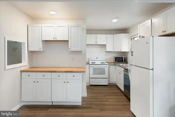 a kitchen with white cabinets and white appliances
