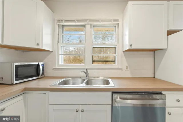 a kitchen with stainless steel appliances granite countertop a sink and a microwave