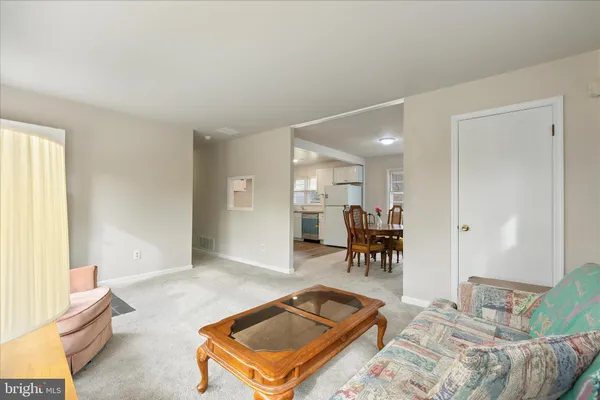 a living room with furniture and a dining table with wooden floor