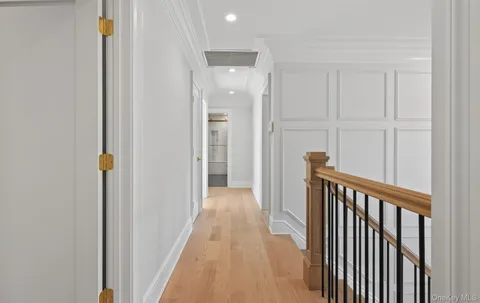 a view of a hallway with wooden floor and staircase