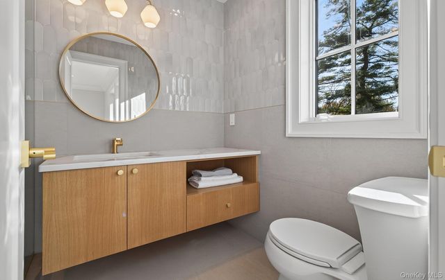 a bathroom with a toilet a sink and mirror