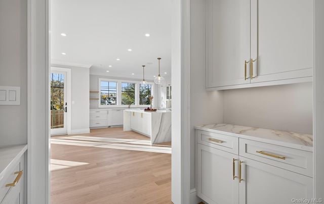 a view of a kitchen with white cabinets and a refrigerator