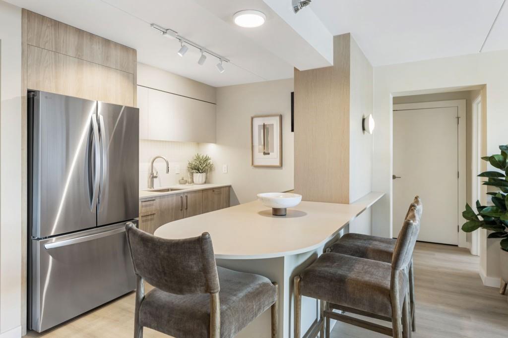 2460 Peachtree Road Northeast, Unit 1105 Atlanta, GA 30305 - Photo 3 of 51 a kitchen with stainless steel appliances a refrigerator a table and chairs