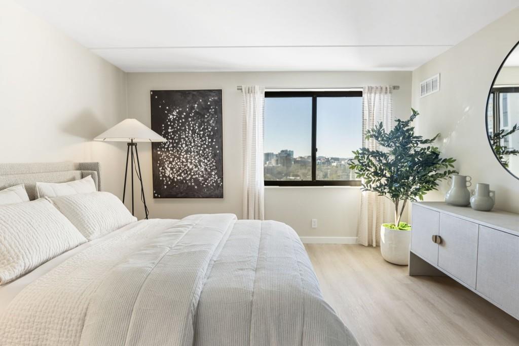 2460 Peachtree Road Northeast, Unit 1105 Atlanta, GA 30305 - Photo 34 of 51 a bedroom with a large bed and a chandelier