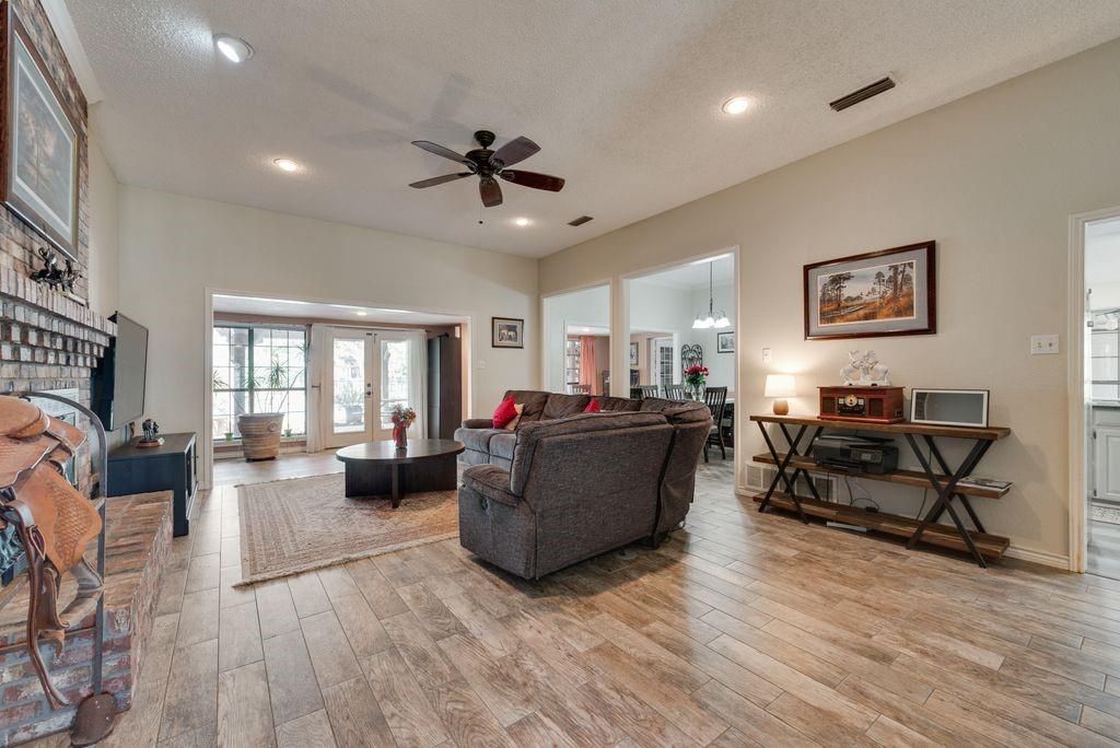 83 Crown Road Willow Park, TX 76087 - Photo 4 of 35 Spacious living area featuring wood-finish flooring, a brick fireplace, recessed lighting, and a ceiling fan