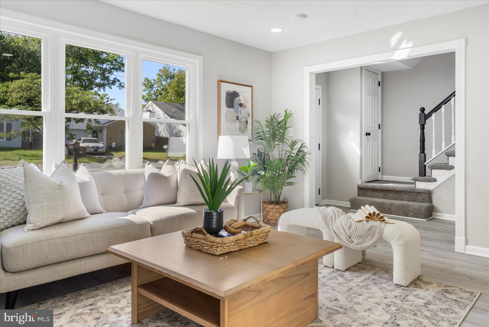 a living room with furniture potted plant and a large window