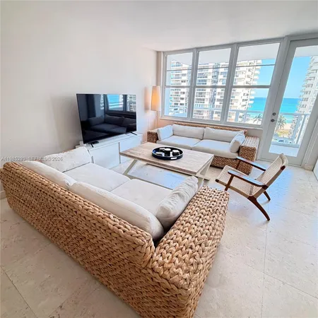 a living room with furniture and floor to ceiling window