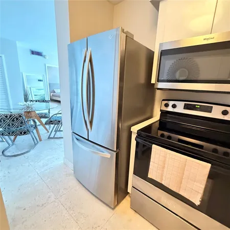 a metallic refrigerator freezer sitting in a kitchen