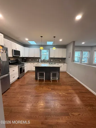 a large kitchen with kitchen island a counter top stainless steel appliances and cabinets