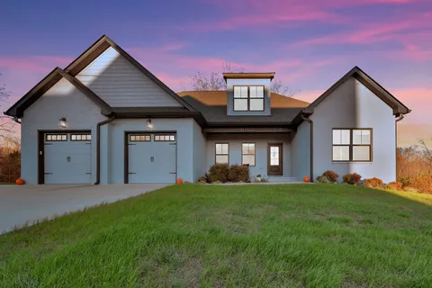 a front view of a house with a yard and garage