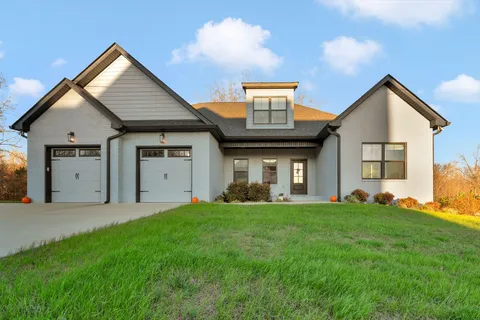 a front view of a house with a yard and garage