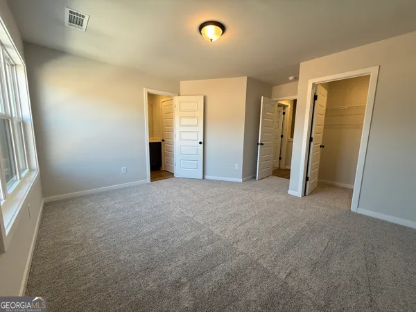 an empty room with closet and mirror
