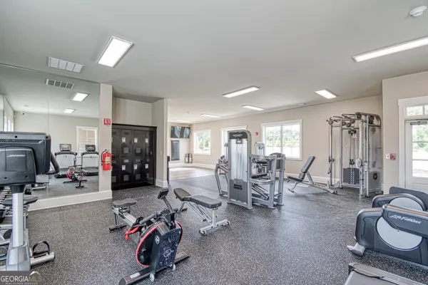a view of a big house in a big yard with plants and large trees