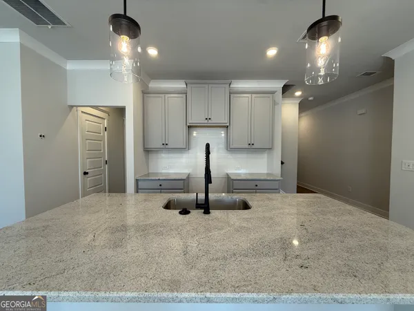 a large kitchen with kitchen island a stove a sink a center island and wooden floor