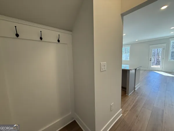 a view of a hallway with wooden floor and staircase