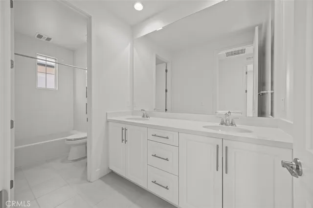 a bathroom with a granite countertop sink a toilet and a mirror
