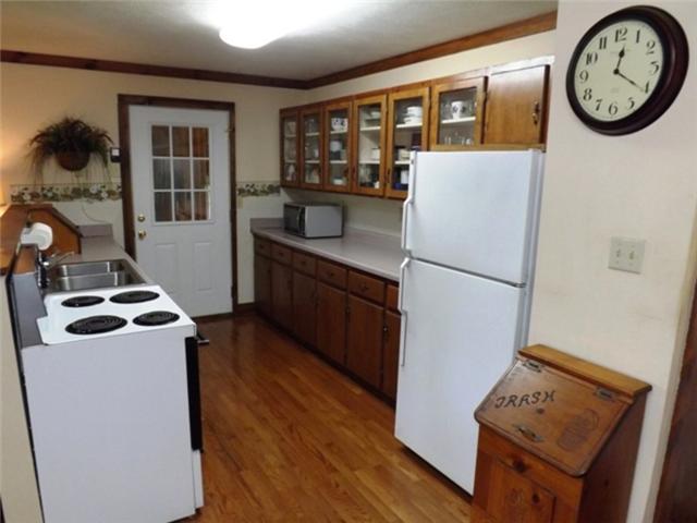 1278 Spence Road Camden, TN 38320 - Photo 14 of 20 a kitchen with stainless steel appliances granite countertop a refrigerator a stove a sink and a dining table with wooden floor