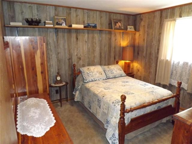 1278 Spence Road Camden, TN 38320 - Photo 16 of 20 a bed sitting in a bedroom next to a window