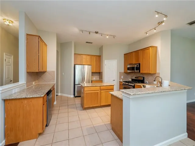 a kitchen with a refrigerator a sink dishwasher stove and oven