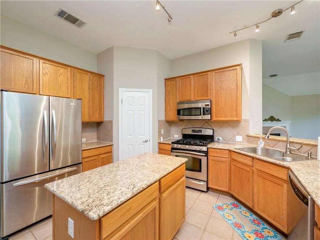 2206 Boneset Trail Round Rock, TX 78665 - Photo 12 of 35 a kitchen with stainless steel appliances granite countertop a stove refrigerator sink and microwave