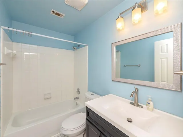 a bathroom with a sink a toilet a mirror and shower