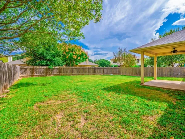 a view of yard with swimming pool and table and chairs under an umbrella