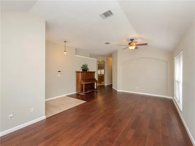 an empty room with wooden floor and furniture