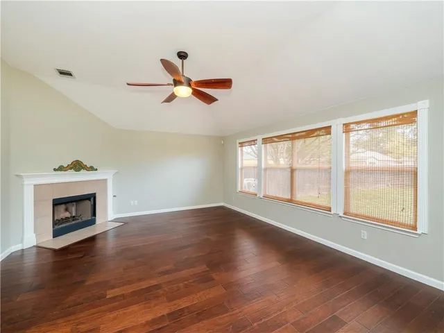 a view of wooden floor fire place and windows in a room