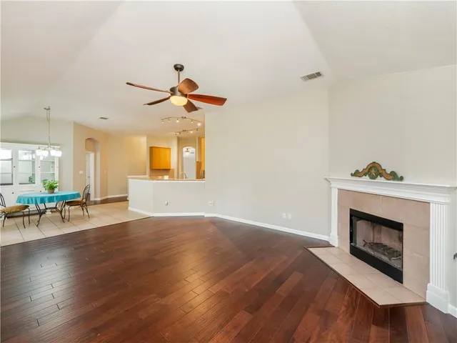an empty room with windows and fireplace