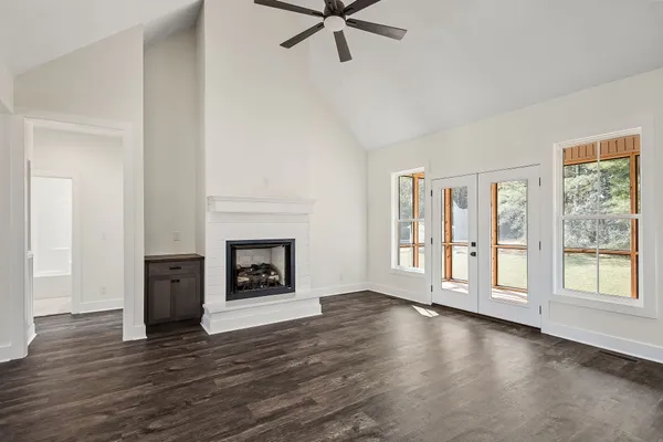 a view of a livingroom with a fireplace wooden floor and window
