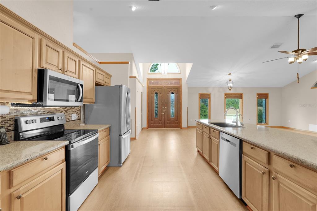 1207 Overlook Road Eustis, FL 32726 - Photo 13 of 44 a kitchen with stainless steel appliances granite countertop a sink stove and refrigerator