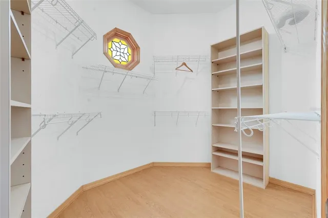 a view of an empty room with closet and wooden floor