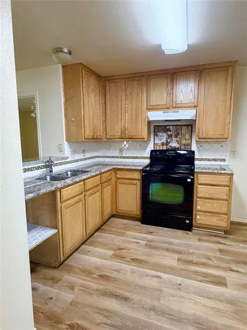 a kitchen with kitchen island granite countertop wooden cabinets and a sink
