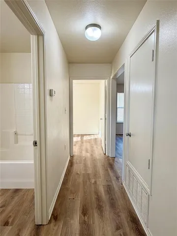 a view of a hallway with wooden floor