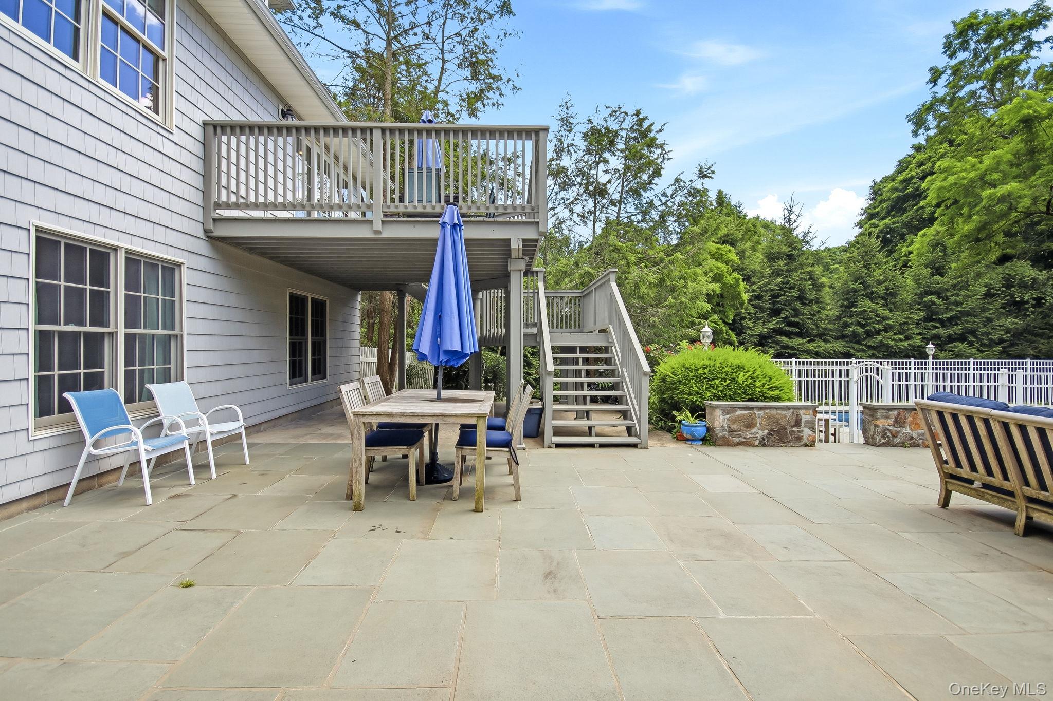 26 Century Ridge Road Purchase, NY 10577 - Photo 35 of 50 Expansive patio with a multi-level deck, featuring a fenced area and mature surrounding trees