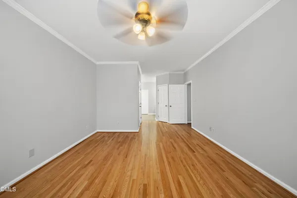 a view of an empty room with a window and chandelier