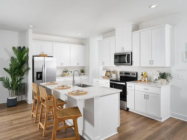 a kitchen with appliances a sink and cabinets