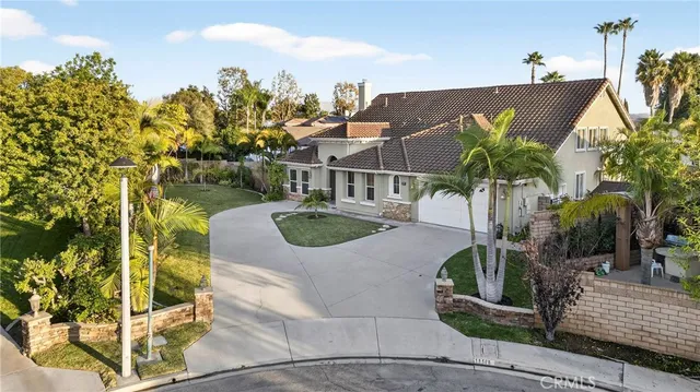 a view of a house with a yard and potted plants