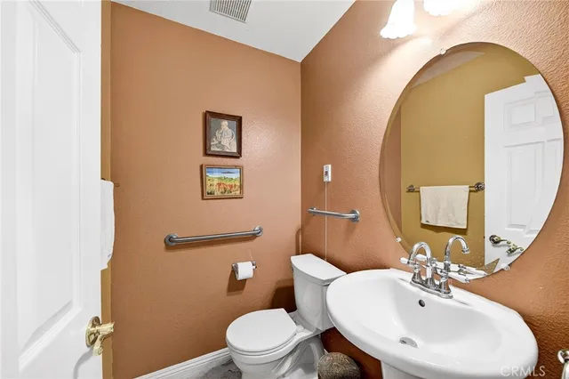 a bathroom with a toilet a sink and mirror